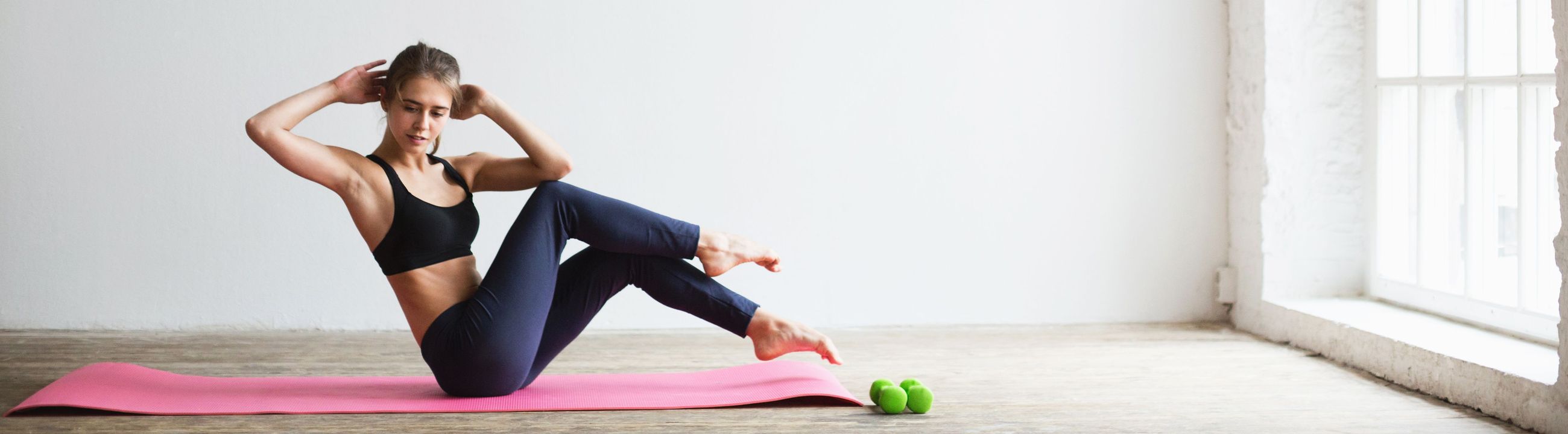 Donna sportiva che esegue butterfly sit-up su un tappetino da yoga